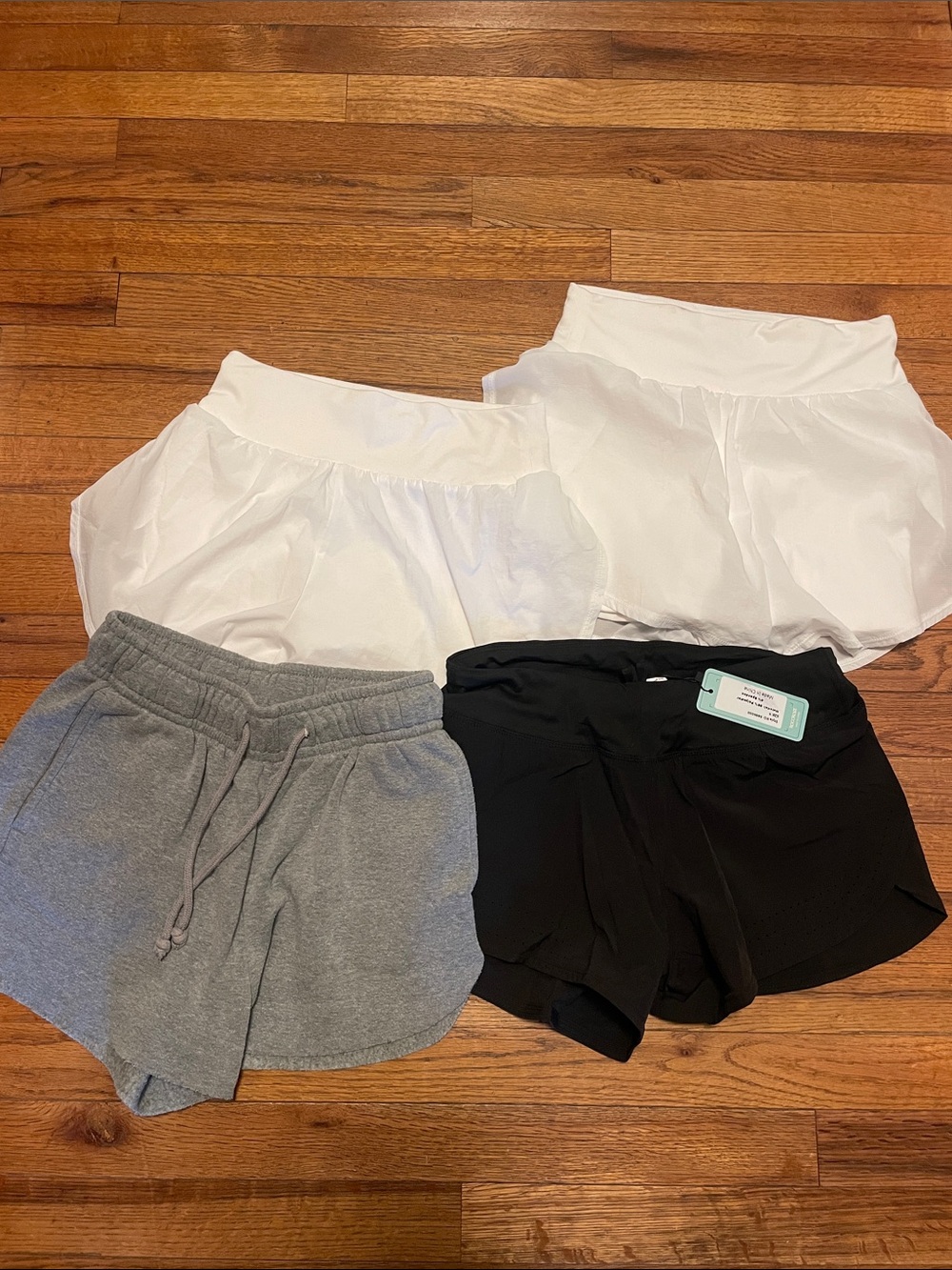 4 Pairs Of Small Shorts. 2 White, 1 Black, 1 Gray